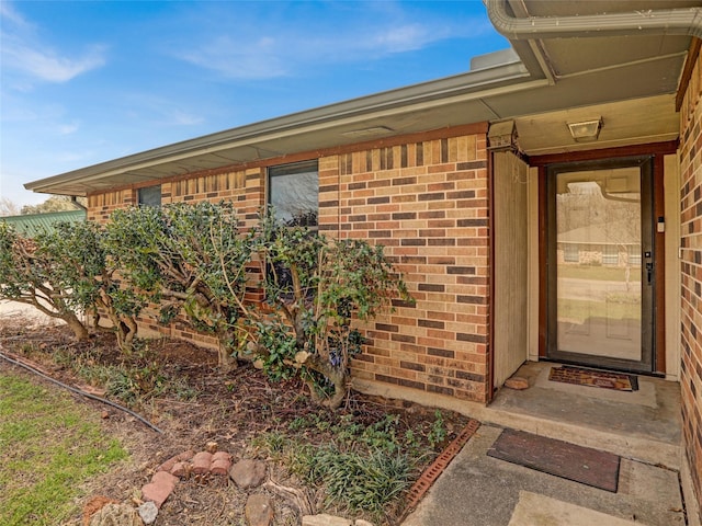 entrance to property featuring brick siding