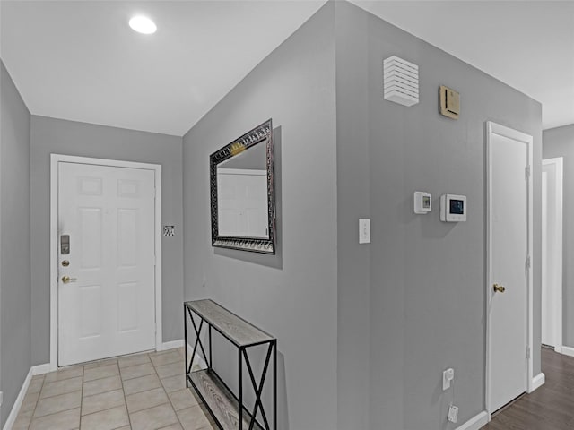 foyer with light tile patterned floors and baseboards