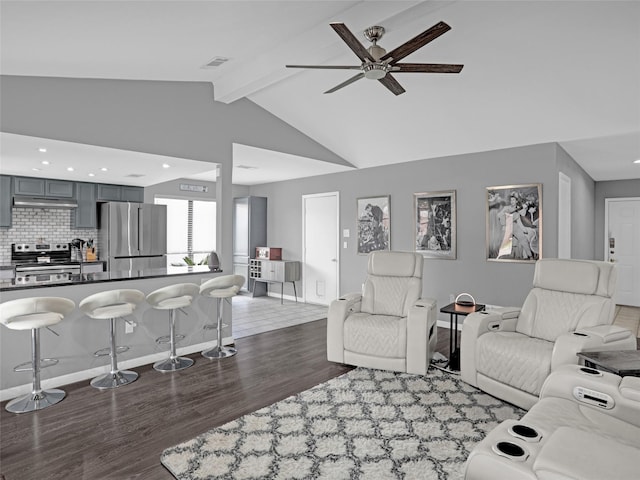 living area featuring vaulted ceiling with beams, dark wood finished floors, baseboards, and ceiling fan