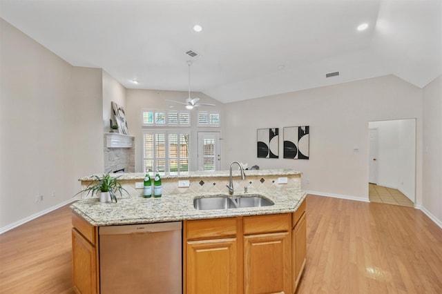 kitchen with lofted ceiling, light wood-style floors, open floor plan, a sink, and dishwasher