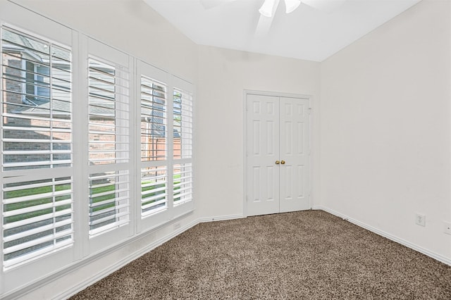 unfurnished bedroom with carpet floors, ceiling fan, baseboards, and a closet