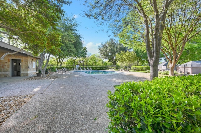 pool featuring fence and a patio