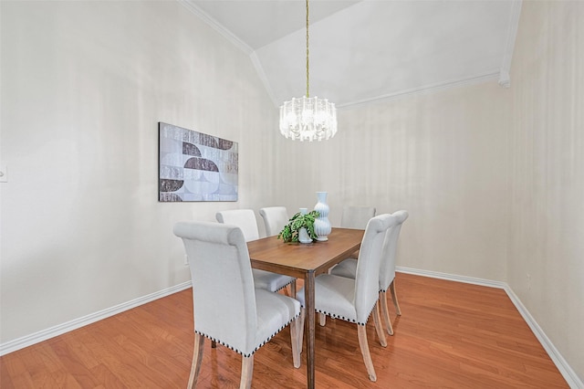 dining area featuring light wood-style floors, lofted ceiling, a chandelier, and baseboards