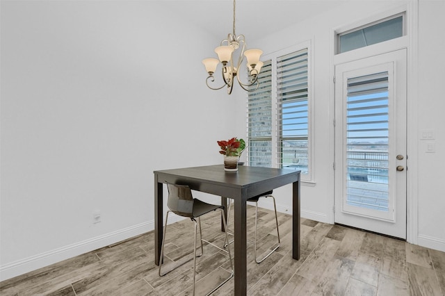 dining room featuring a notable chandelier, light wood-style floors, and baseboards