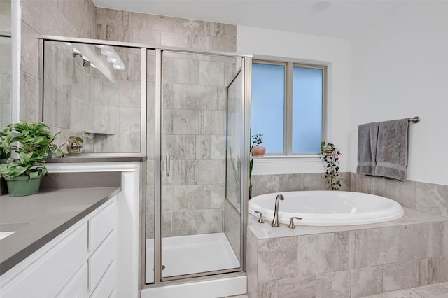 full bathroom featuring a shower stall, vanity, and a garden tub