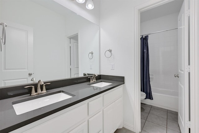 full bathroom featuring tile patterned floors, toilet, double vanity, and a sink