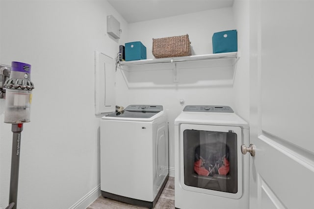 laundry room with light wood-type flooring, baseboards, laundry area, and washing machine and clothes dryer