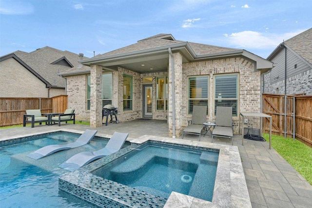 back of house featuring a patio, brick siding, and a fenced backyard