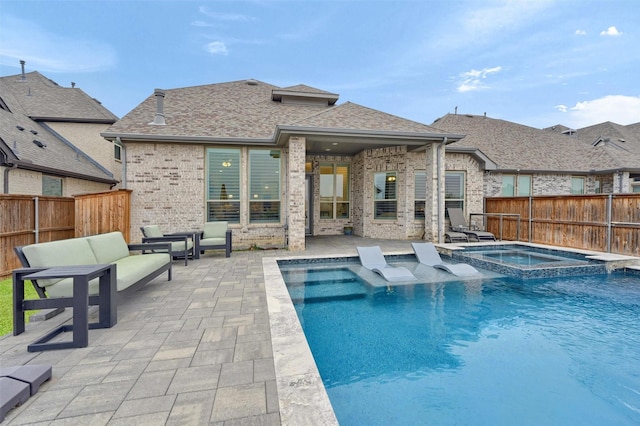 view of pool featuring a patio area, a pool with connected hot tub, and a fenced backyard