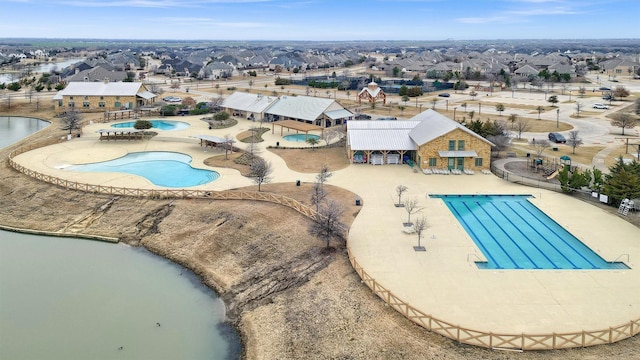 pool with a patio area, a residential view, a hot tub, and fence