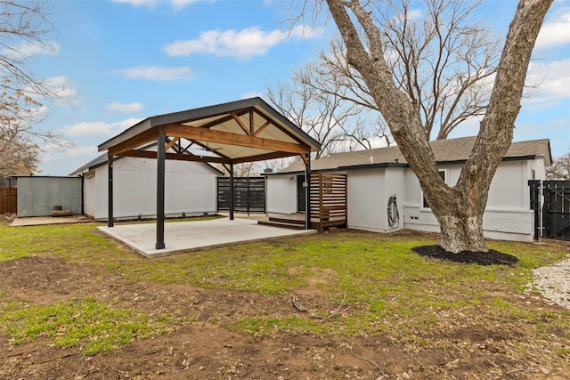 rear view of property with a gazebo, roof with shingles, and fence