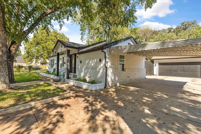 view of side of home with a garage, an attached carport, brick siding, and driveway