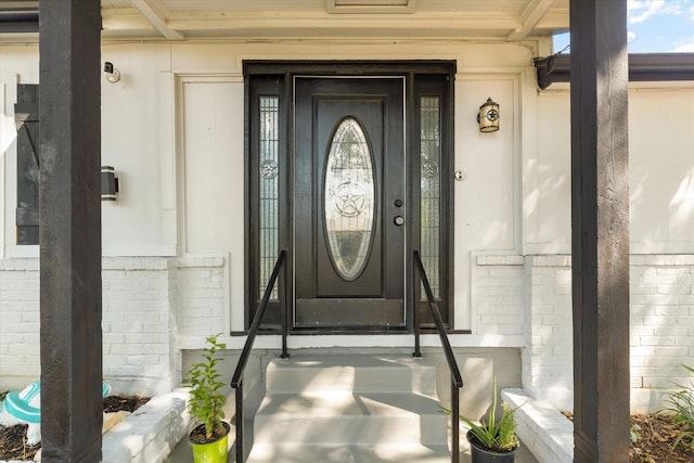 view of exterior entry with brick siding