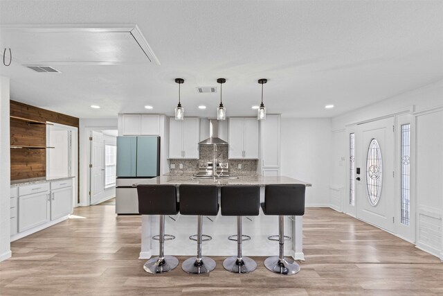 kitchen featuring white cabinetry, a barn door, appliances with stainless steel finishes, and light wood-style floors