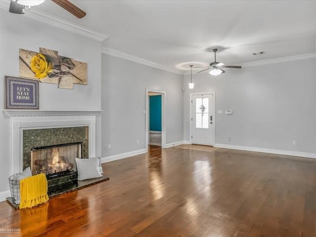 unfurnished living room with ceiling fan, ornamental molding, a fireplace, and wood-type flooring