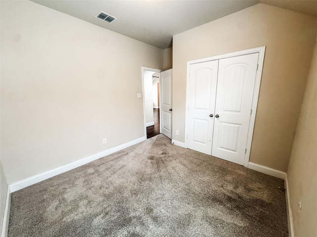 unfurnished bedroom with baseboards, visible vents, carpet floors, and a closet