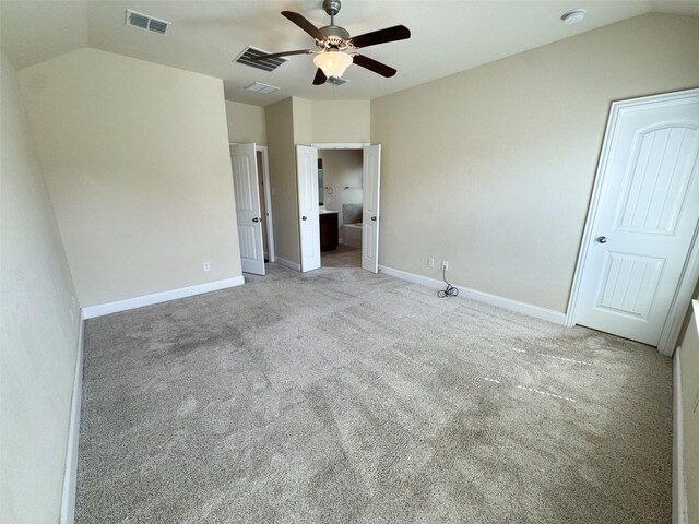 unfurnished bedroom with lofted ceiling, carpet flooring, and visible vents