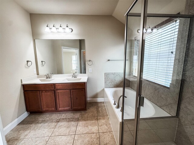 bathroom with a garden tub, vaulted ceiling, double vanity, and a sink