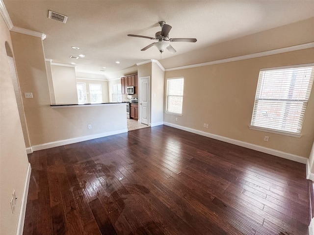 unfurnished living room featuring a ceiling fan, baseboards, visible vents, ornamental molding, and hardwood / wood-style flooring