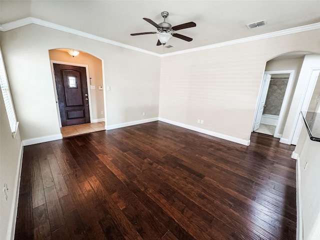 interior space with hardwood / wood-style floors, visible vents, baseboards, arched walkways, and ornamental molding