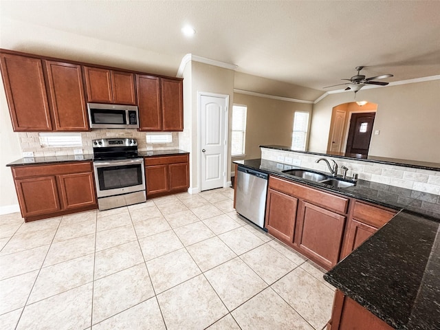 kitchen with a sink, stainless steel appliances, backsplash, and light tile patterned flooring