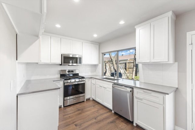 kitchen with stainless steel appliances, white cabinetry, and decorative backsplash