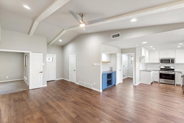 unfurnished living room with visible vents, a ceiling fan, vaulted ceiling, wood finished floors, and baseboards