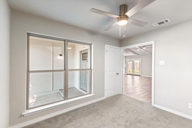 unfurnished room with visible vents, baseboards, ceiling fan, carpet, and french doors