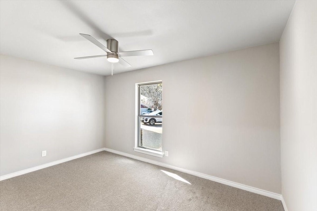 spare room featuring ceiling fan, carpet flooring, and baseboards