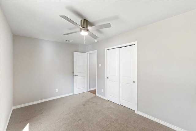 unfurnished bedroom with baseboards, visible vents, a ceiling fan, carpet, and a closet