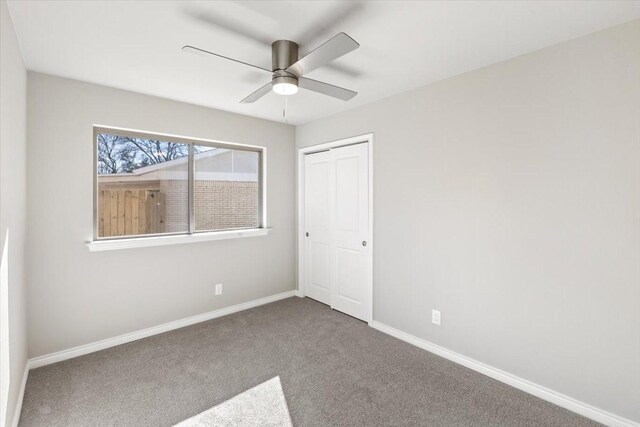 unfurnished bedroom featuring ceiling fan, a closet, carpet flooring, and baseboards