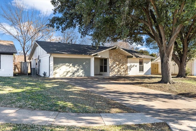 single story home featuring a garage, central AC, stone siding, driveway, and board and batten siding