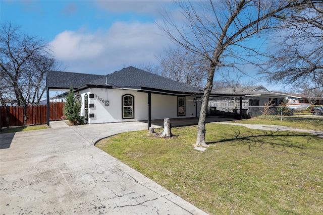 ranch-style home with driveway, fence, a front lawn, and stucco siding