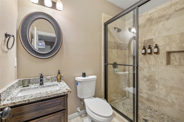 full bathroom with toilet, a stall shower, a textured wall, and vanity