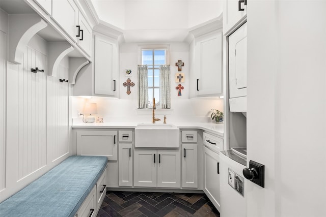 kitchen with white cabinetry, light countertops, and a sink