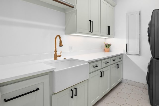 kitchen with white cabinets, light countertops, a sink, and light tile patterned floors