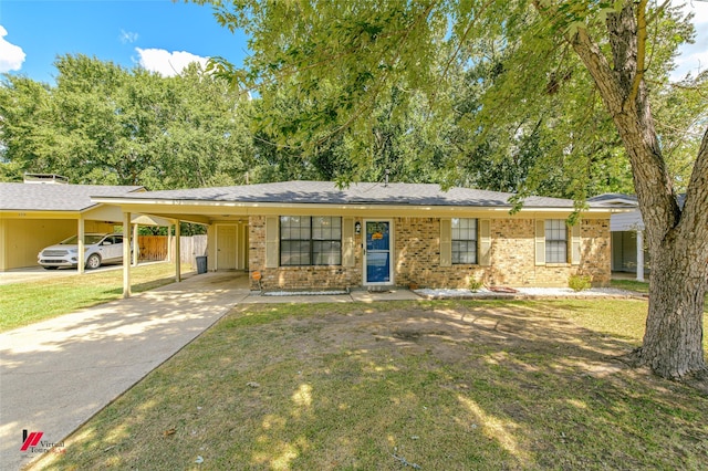 ranch-style house featuring an attached carport, concrete driveway, brick siding, and a front yard