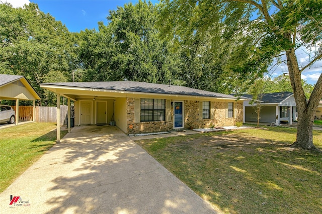 ranch-style house featuring a front yard, brick siding, fence, and driveway