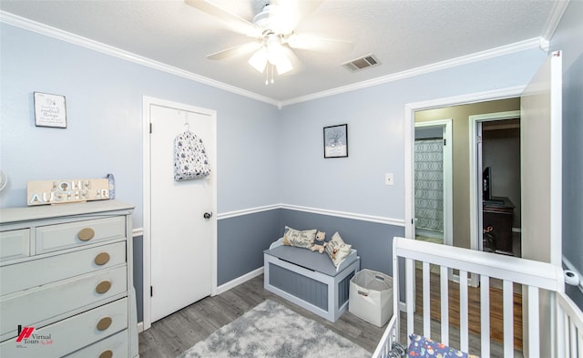 bedroom with crown molding, visible vents, ceiling fan, a textured ceiling, and light wood-type flooring