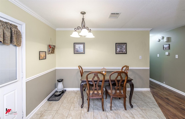 dining area featuring baseboards, visible vents, a notable chandelier, and ornamental molding