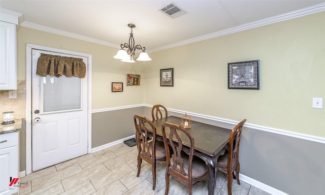 dining area featuring an inviting chandelier, baseboards, visible vents, and crown molding