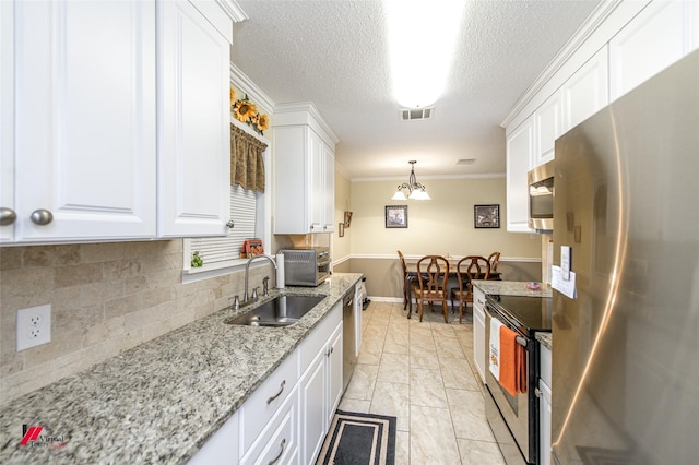 kitchen featuring appliances with stainless steel finishes, a sink, visible vents, and white cabinetry