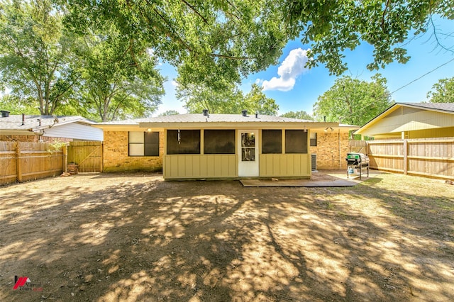 rear view of property with a fenced backyard and brick siding