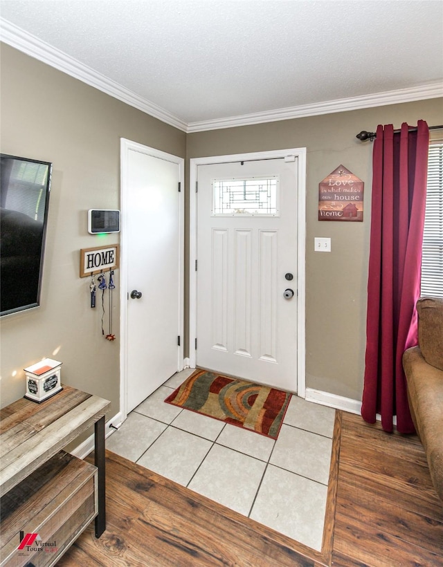 entrance foyer featuring tile patterned flooring, baseboards, and crown molding