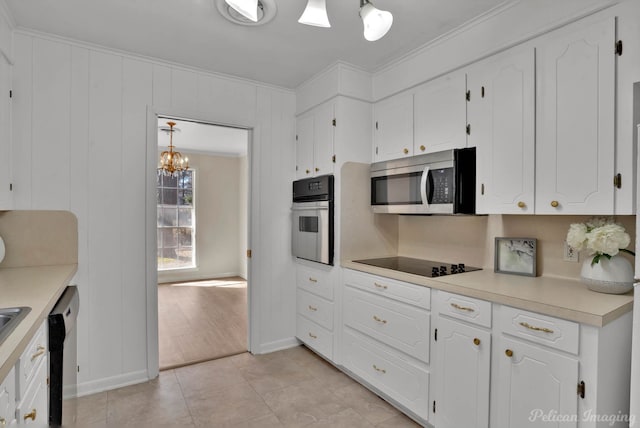 kitchen featuring white cabinets, appliances with stainless steel finishes, light countertops, and ornamental molding