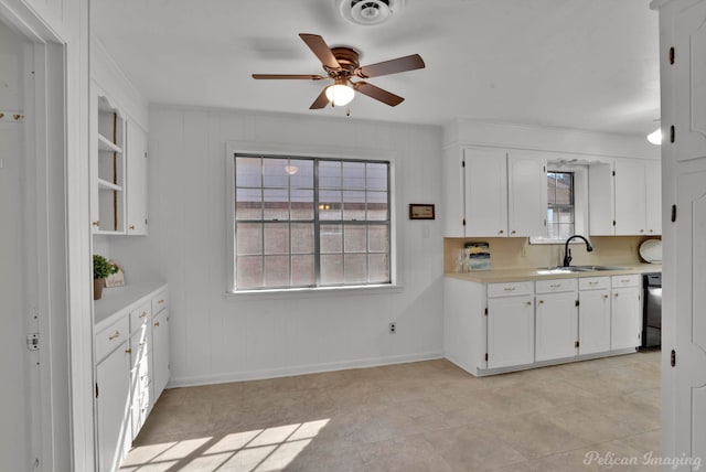 kitchen featuring light countertops, white cabinets, visible vents, and a sink