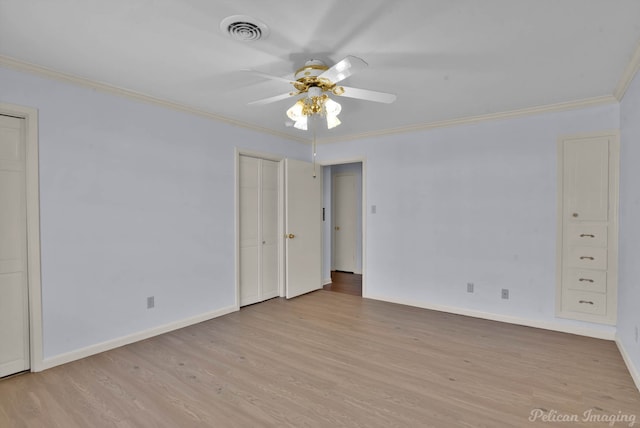 spare room with visible vents, wood finished floors, and crown molding