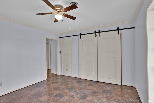 unfurnished bedroom with visible vents, crown molding, baseboards, a barn door, and a closet