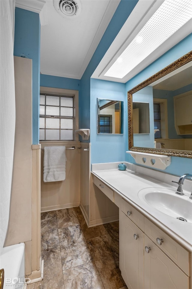 bathroom with vanity, crown molding, and visible vents