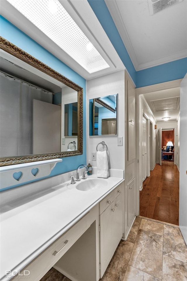 bathroom featuring visible vents, vanity, and ornamental molding